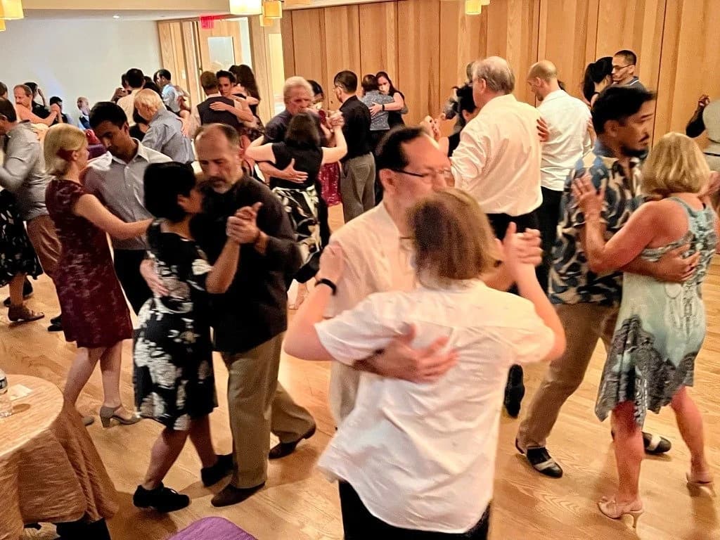 Two dancers in close embrace at a Tango Mercurio milonga